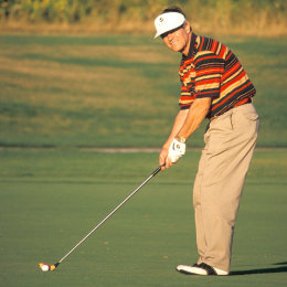 Mann beim Abschlag auf dem Golfplatz