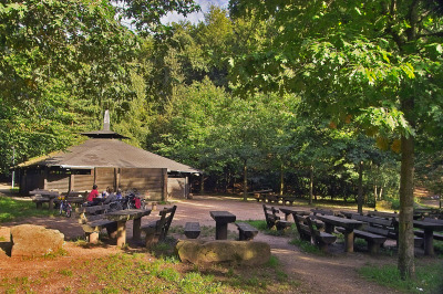 Einige feste Sitzplätze sind im Freien. Die Hütte selbst ist aus Holz und nicht ganz geschlossen, dafür aber überdacht.