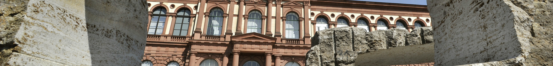 Blick auf das Museum Pfalzgalerie durch eine rechteckige Steinskulptur