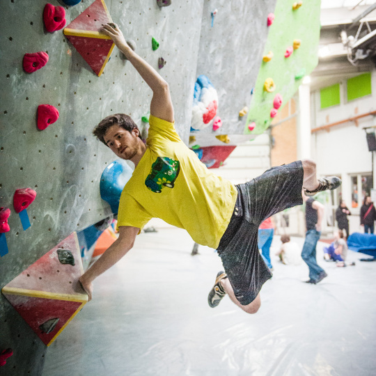 Junger Mann an Boulderwand