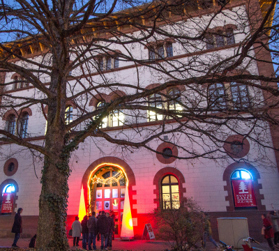 Blick auf die erleuchtete Fruchthalle bei Dunkelheit während des Kulturmarktes. 