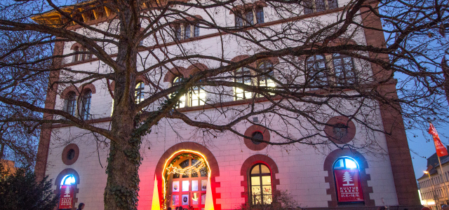 Blick auf die erleuchtete Fruchthalle bei Dunkelheit während des Kulturmarktes. 