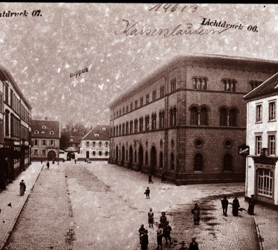 Eine schwarz-weiß Fotografie der Außenansicht der Fruchthalle. Statt der geteerten Straße von heute, sieht man einen gepflasterten Platz.