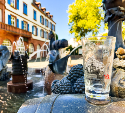 Das Dubbeglas mit dem Motiv Kaiserbrunnen vor dem Kaiserbrunnen. 