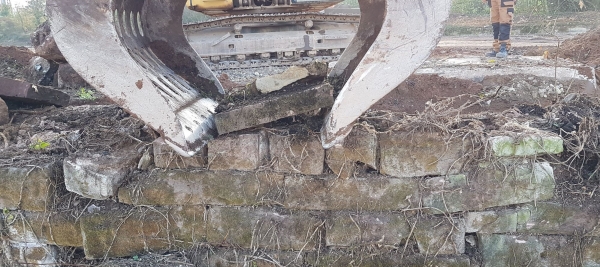 Bagger zerstört Trockenmauer